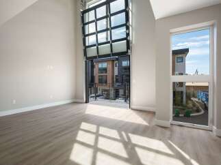 Experience modern living in this spacious, light-filled home featuring a dramatic floor-to-ceiling glass garage door that opens to a private balcony.