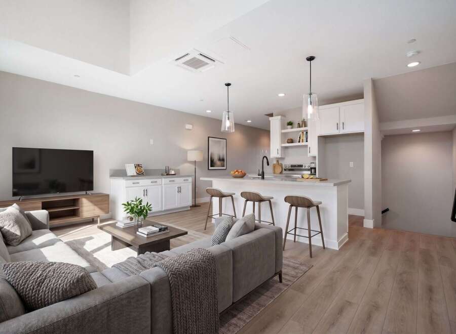Experience modern living in this open-concept condo featuring a sleek kitchen with a breakfast bar and pendant lighting, perfect for entertaining.