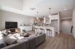 Experience modern living in this open-concept condo featuring a sleek kitchen with a breakfast bar and pendant lighting, perfect for entertaining.