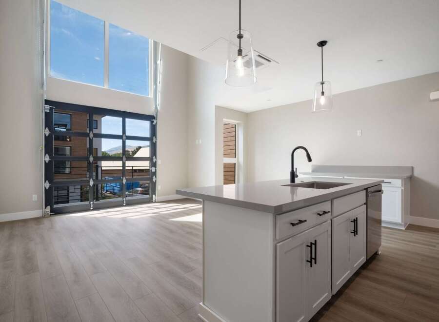Experience modern living in this stunning loft-style apartment featuring a dramatic floor-to-ceiling glass garage door that opens to breathtaking views.