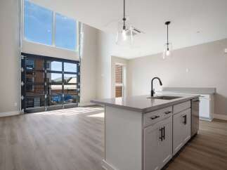 Experience modern living in this stunning loft-style apartment featuring a dramatic floor-to-ceiling glass garage door that opens to breathtaking views.