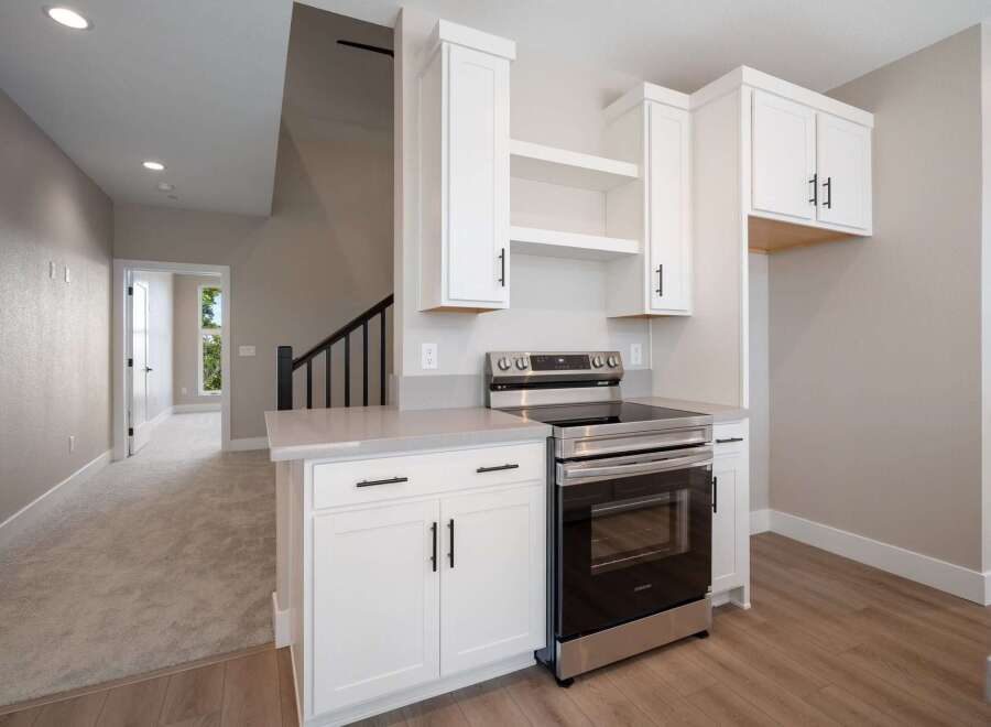 Discover modern living in this stunning kitchen featuring sleek white cabinetry and a stainless steel range.