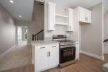 Discover modern living in this stunning kitchen featuring sleek white cabinetry and a stainless steel range.