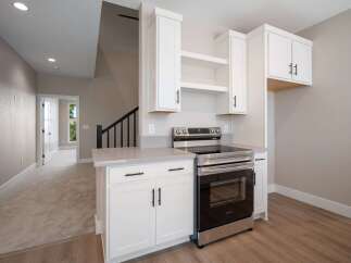 Discover modern living in this stunning kitchen featuring sleek white cabinetry and a stainless steel range.