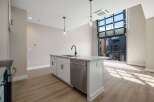 Experience modern living in this stunning apartment featuring a sleek kitchen island with a built-in sink and dishwasher.