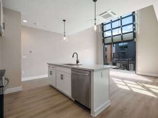 Experience modern living in this stunning apartment featuring a sleek kitchen island with a built-in sink and dishwasher.