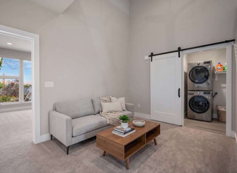 Discover modern living in this stylish space featuring a comfortable gray sofa and a sleek wooden coffee table.