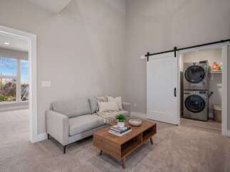 Discover modern living in this stylish space featuring a comfortable gray sofa and a sleek wooden coffee table.