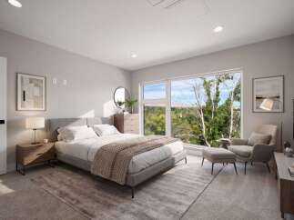 Experience modern comfort in this beautifully staged bedroom, featuring a plush king-sized bed and a cozy reading nook with an armchair and ottoman.