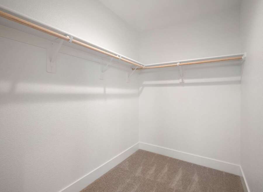 This spacious walk-in closet offers ample storage with its extensive shelving and hanging rods.
