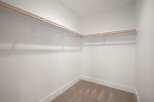 This spacious walk-in closet offers ample storage with its extensive shelving and hanging rods.