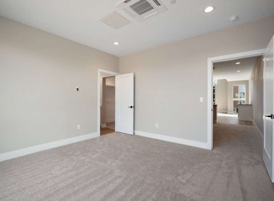 Step into this inviting bedroom, featuring plush carpeting and neutral-toned walls for a serene atmosphere.