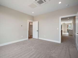 Step into this inviting bedroom, featuring plush carpeting and neutral-toned walls for a serene atmosphere.