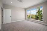 Experience modern living in this spacious room featuring a large picture window that floods the space with natural light and offers stunning views of the surrounding greenery.