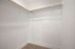 This spacious walk-in closet offers ample storage with dual-level hanging rods, perfect for organizing your wardrobe.