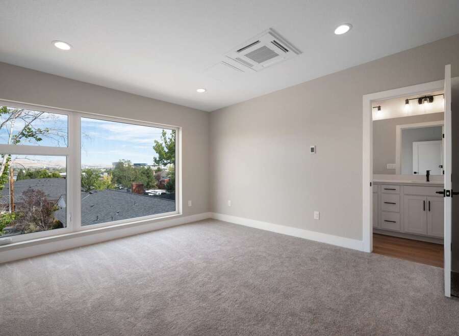 Experience breathtaking views from this spacious bedroom, featuring a large picture window that floods the room with natural light.