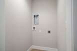 This laundry room is equipped with essential hookups for your washer and dryer, including a dryer vent and water connections.