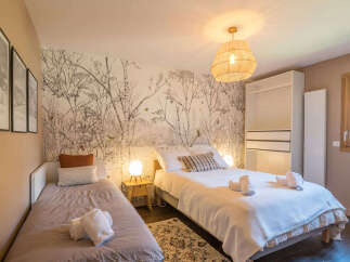 This charming bedroom features a unique birch tree wallpaper that creates a serene and natural ambiance.