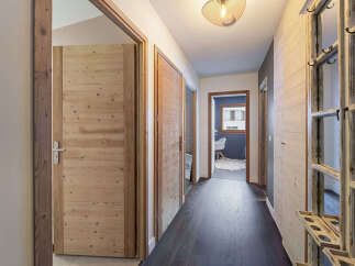 Step into this charming hallway featuring warm wooden doors and a rustic wooden accent wall.