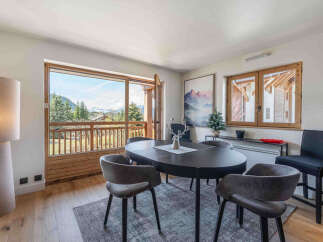 Experience breathtaking mountain views from this elegant dining area, featuring a sleek oval table perfect for intimate gatherings.