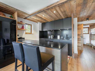 Experience modern alpine living in this stylish kitchen featuring sleek dark cabinetry and a spacious island with bar seating.