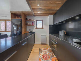 Experience modern mountain living in this sleek kitchen, featuring dark cabinetry and granite countertops.