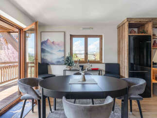 Experience cozy mountain living in this charming dining area, featuring a sleek dark round table perfect for intimate gatherings.