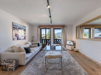 Experience mountain living in this beautifully appointed living room, featuring a spacious white sofa adorned with plush cushions and a large scenic artwork.
