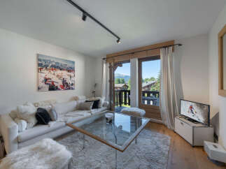 Experience mountain living in this charming living room, featuring a plush white sofa perfect for relaxing after a day on the slopes.