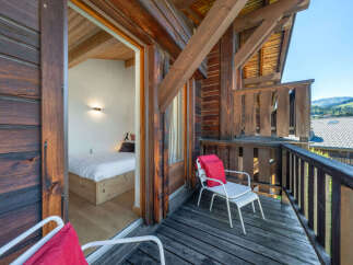 Experience charming alpine living with this inviting balcony overlooking a picturesque mountain landscape.