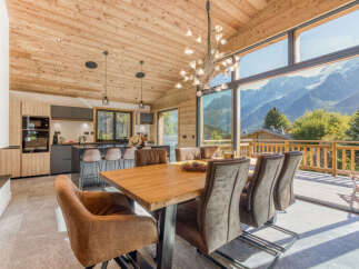 Experience luxury mountain living in this stunning chalet featuring a spacious open-plan living area with a modern kitchen and dining space.