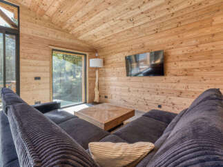 Experience rustic luxury in this stunning wooden cabin living room, featuring a plush sectional sofa perfect for cozy evenings.
