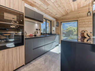 Experience modern luxury in this stunning kitchen, featuring sleek grey cabinetry and integrated appliances.
