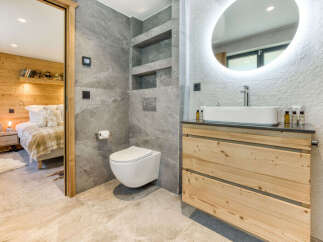 Experience modern alpine living in this stunning bathroom featuring a sleek wall-mounted toilet and a spacious vanity with a rectangular vessel sink.