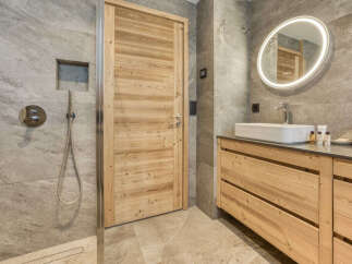 Experience modern luxury in this stunning bathroom featuring a spacious walk-in shower with sleek chrome fixtures and a built-in niche for toiletries.