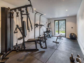 Elevate your fitness routine in this dedicated home gym, featuring a comprehensive multi-gym system for a full-body workout.