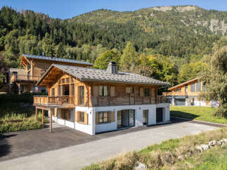Experience luxury mountain living in this stunning chalet, featuring a modern design with warm wood accents and expansive windows that frame breathtaking forest and mountain views.