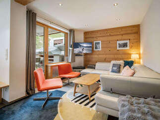 Experience cozy mountain living in this charming living room, featuring a plush white sectional sofa adorned with decorative pillows and a soft throw blanket.