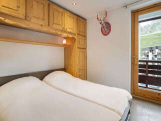 Experience cozy mountain living in this charming bedroom featuring a comfortable bed with plush white linens, perfect for unwinding after a day of adventure.