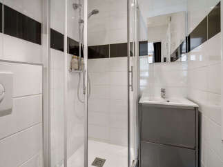 Experience modern comfort in this stylish bathroom featuring a sleek glass-enclosed shower and a convenient vanity with ample storage.