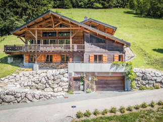 Experience luxury mountain living in this stunning wooden chalet, nestled amidst lush green hills and mature trees.