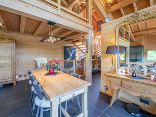Experience rustic charm in this stunning log cabin dining area, featuring a grand wooden table perfect for family gatherings.