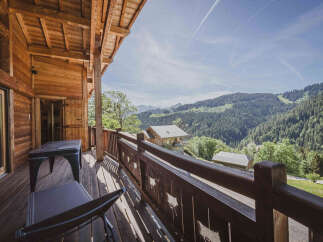 Experience breathtaking mountain views from this charming wooden chalet's spacious balcony.