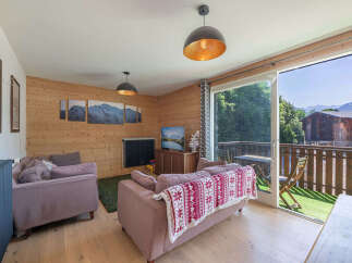 Experience mountain living in this charming living room featuring cozy seating and a stunning view from the balcony.