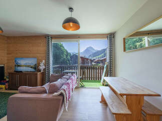 Experience breathtaking mountain views from this charming living space, featuring a cozy sofa and a large television for entertainment.