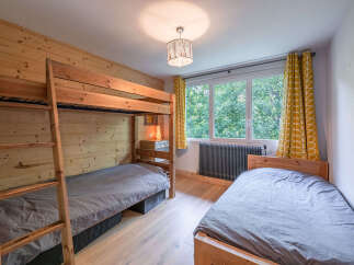 This charming bedroom features a space-saving wooden bunk bed, perfect for families or accommodating guests.