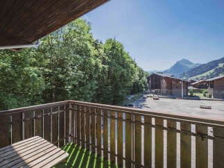 Enjoy breathtaking mountain views from this charming balcony, complete with a rustic wooden table perfect for morning coffee.