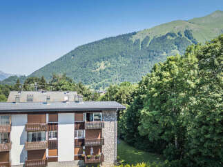 Experience breathtaking mountain views from this charming apartment building, nestled amidst lush greenery.