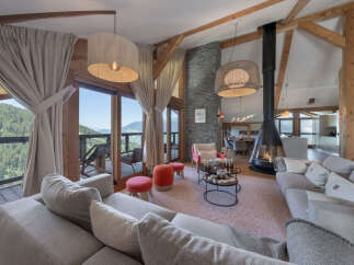 Experience luxurious mountain living in this stunning open-concept living area, featuring a modern suspended fireplace and breathtaking panoramic views.