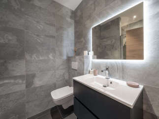 Experience modern elegance in this stylish bathroom, featuring sleek grey stone tiles that create a sophisticated ambiance.
